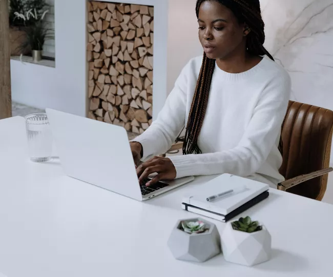 Woman in white long sleeve shirt with laptop